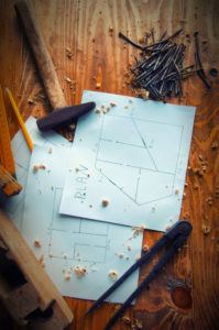 Equipment carpenter and plans to build on a wooden wooden background