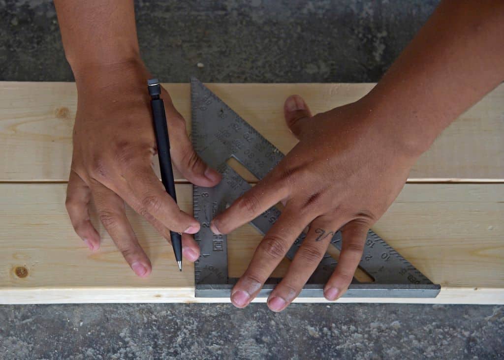 engineer uses a speed square to accurately cut blocks of wood