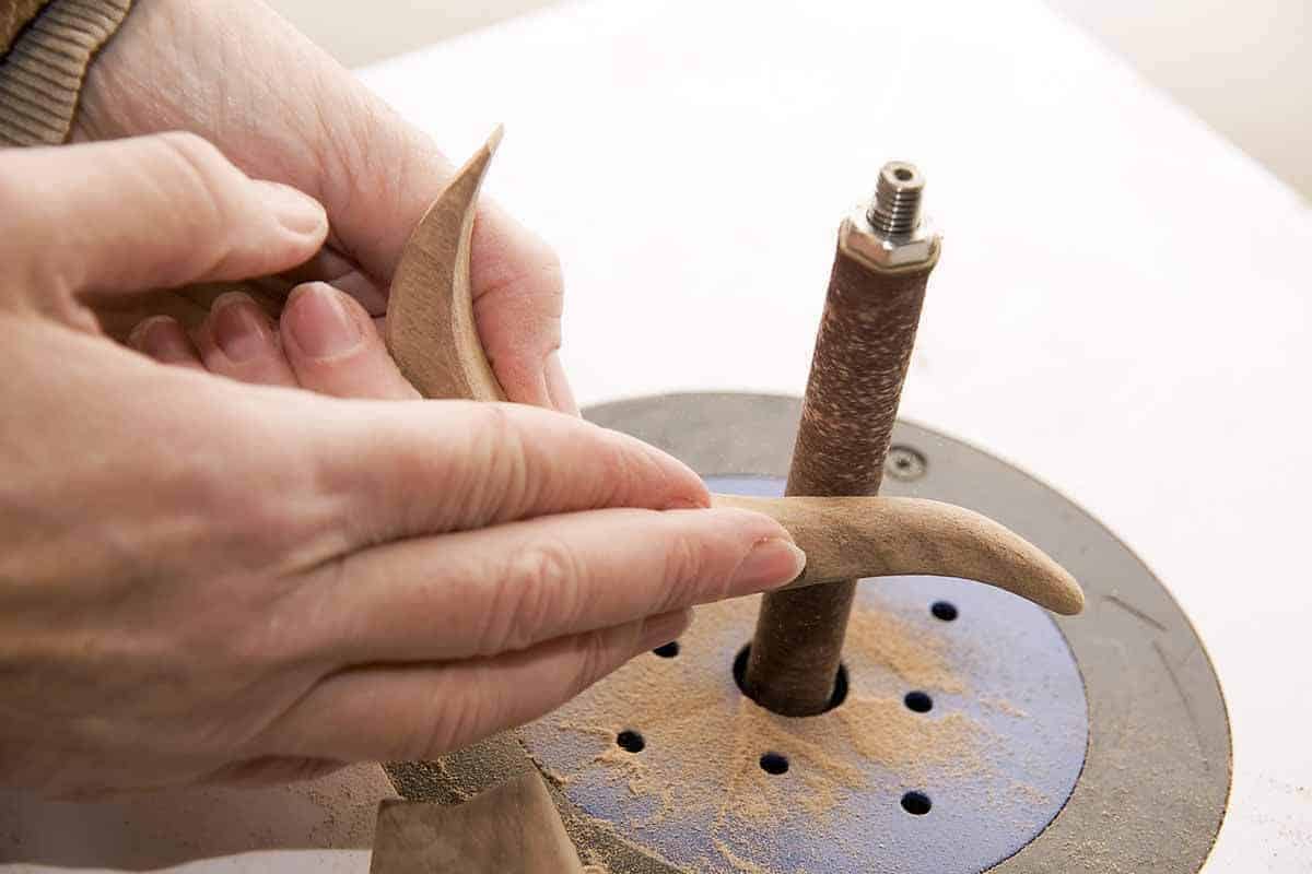 woman curving wood using a sander
